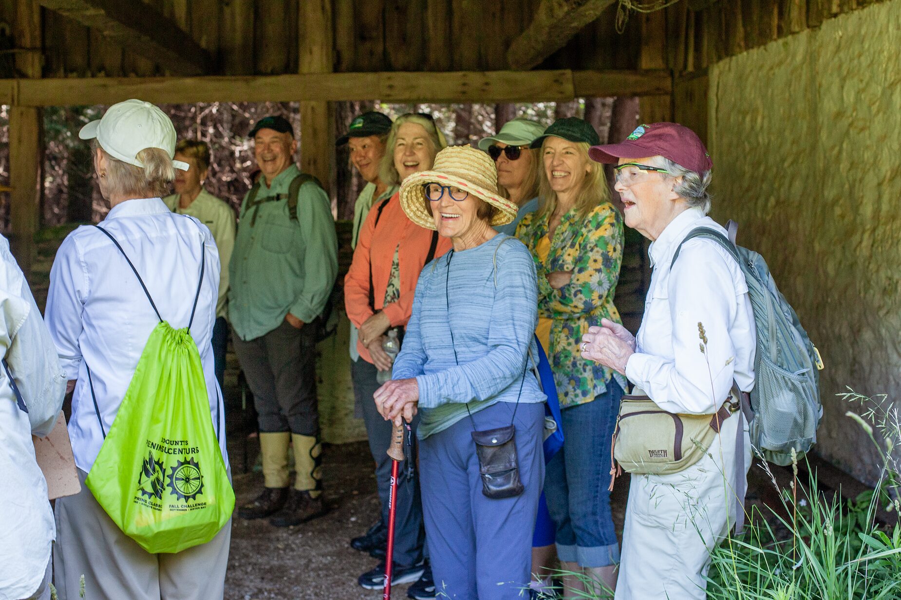 A group gathered inside a timber trailside shelter during an outing at Three Springs